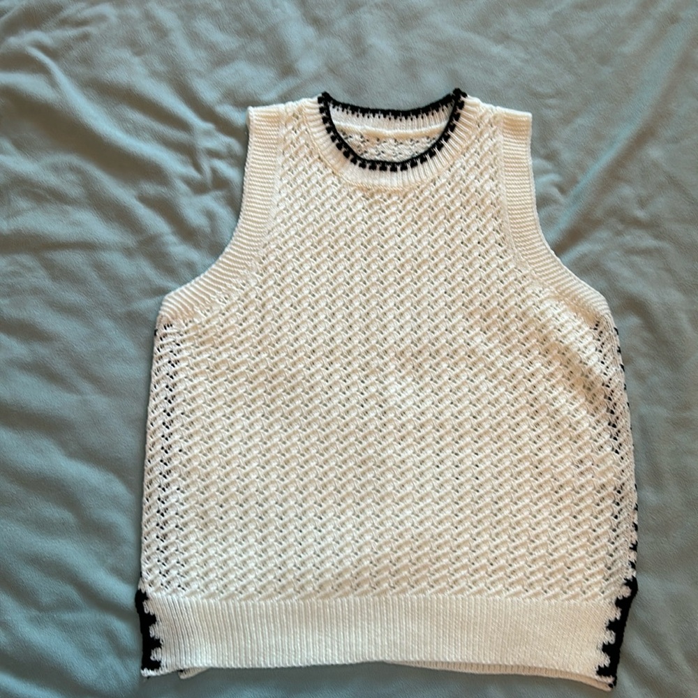 White crochet sweater vest. Black stitch details on the side.